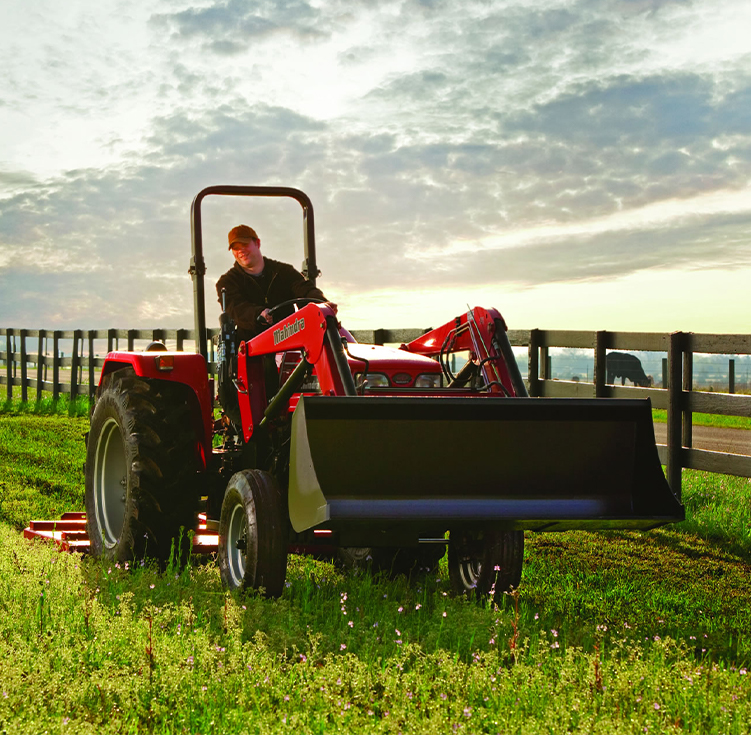 Man riding a Mahindra tractor in a field